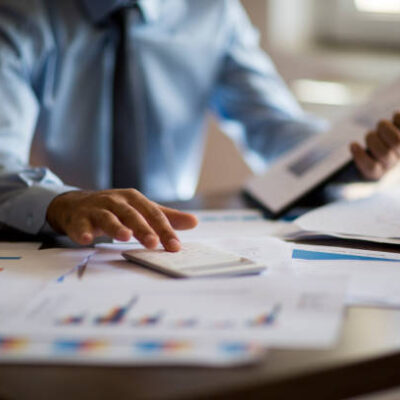 Business accounting concept, Business man using calculator with computer laptop, budget and loan paper in office.