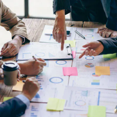 Group of business people holding pen brainstorm financial analysis with financial graph document Calculator and computer to calculate budget and loan. Investment. Vertical image.